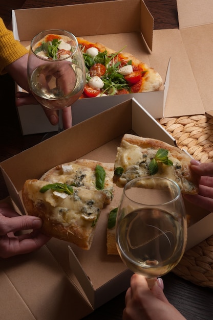 As pessoas comem pizza italiana com vinho branco. conceito: entrega de comida