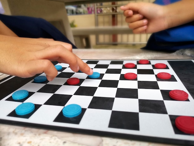 Foto as pessoas estão jogando damas fechando o conceito de um jogo de tabuleiro