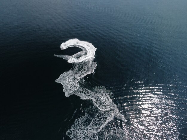 As pessoas estão jogando jet ski no mar, deixando pegadas brancas abstratas no topo da água