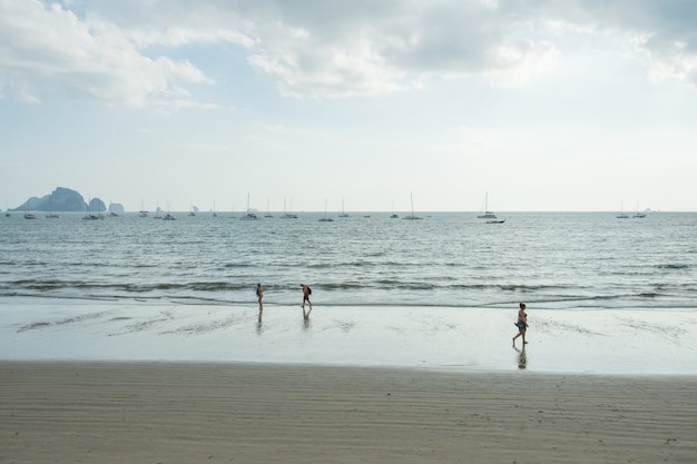 As pessoas relaxam e caminham na praia Ao Nang antes do pôr do sol