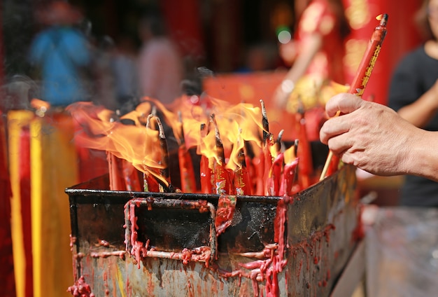 As pessoas rezam respeito com vela queimando para Deus no dia do ano novo chinês.