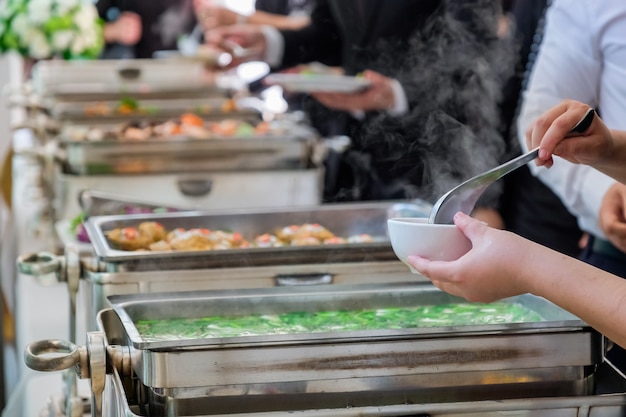 As pessoas são desfrutar de buffet com fundo desfocado