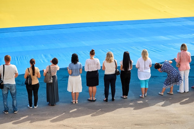 Foto as pessoas seguram a bandeira ucraniana com as mãos eles olham para frente dia da bandeira da ucrânia um feriado para as pessoas