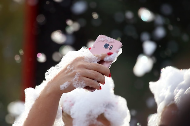 As pessoas tiram fotos de si mesmas com um telefone celular em uma discoteca