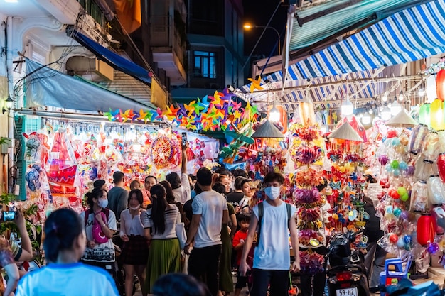 As pessoas visitam e compram lanternas tradicionais coloridas penduradas durante o Festival do Meio do Outono