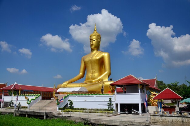 As pessoas visitam e rezam a imagem da estátua do Grande Buda Dourado no Templo Wat Bangchak em 21 de novembro de 2015 em Nonthaburi Tailândia