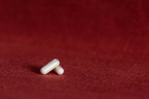 Foto as pílulas de remédio xawhite estão sobre um fundo cor de vinho, médicos do dia da saúde e remédios que tomam vitaminas, tratamento de doenças