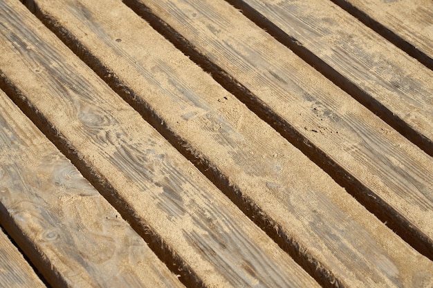 As pranchas de madeira da velha ponte estão cobertas de areia como pano de fundo