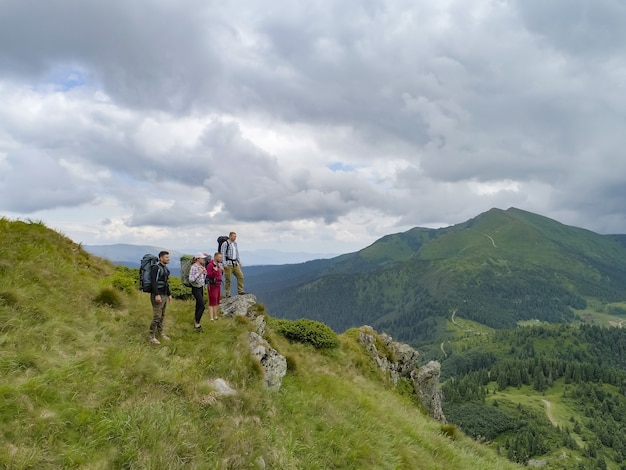 As quatro pessoas de pé na montanha pitoresca