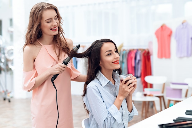 Foto as raparigas fazem o estilo do cabelo no showroom.