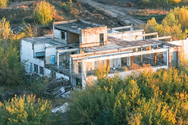 As ruínas de uma antiga empresa nos raios do sol poente Destruiu a antiga fábrica Edifícios industriais abandonados