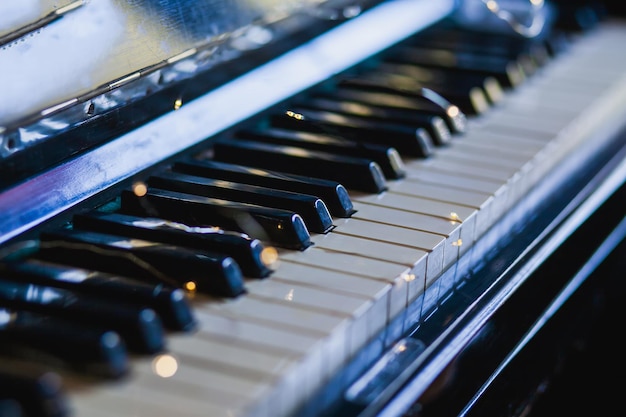 As teclas de um piano antigo ao fundo iluminam-se com destaques.