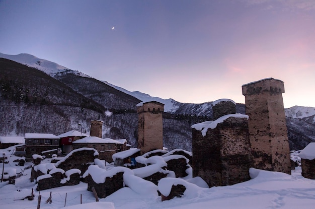 As torres Svan durante o pôr do sol anexadas a casas residenciais na província de Ushguli são o símbolo de Svaneti, o Cáucaso, Geórgia