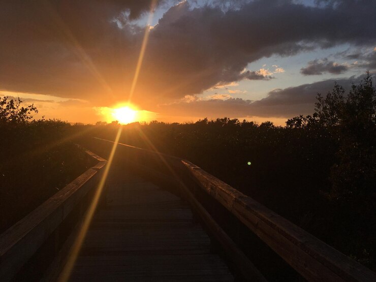Foto as trilhas do caminho-de-ferro contra o céu durante o pôr-do-sol