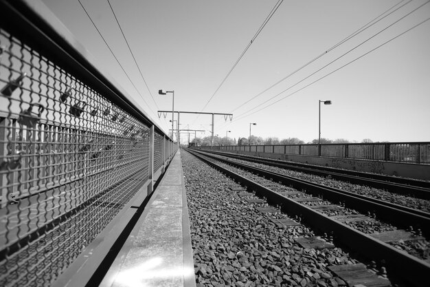 As trilhas do caminho-de-ferro contra o céu limpo