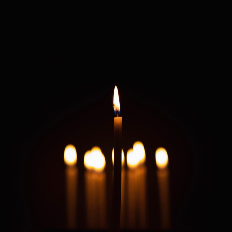 As velas foram acesas na escuridão para realizar alguns rituais como luz laranja e foco em algumas velas para destacá-las Algumas estão fora de foco para profundidade de campo e bokeh