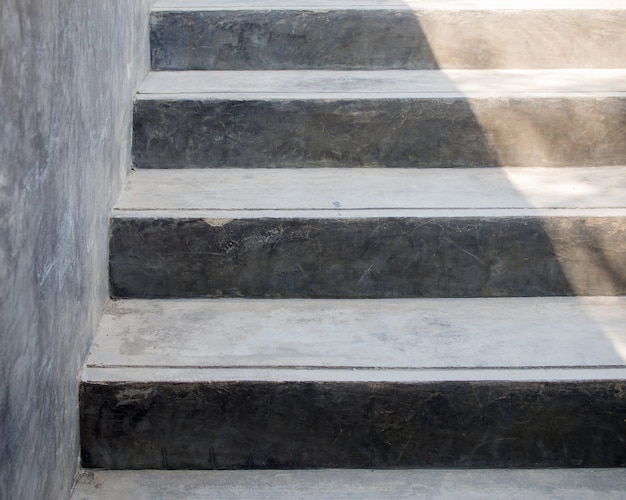 As velhas escadas de cimento feitas de concreto com manchas de água