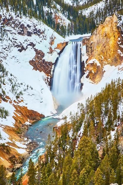 As vibrantes Cataratas Superiores de Yellowstone no inverno por falésias