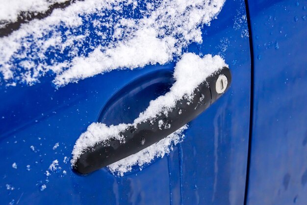 Asa de coche azul en el primer plano de la nieve