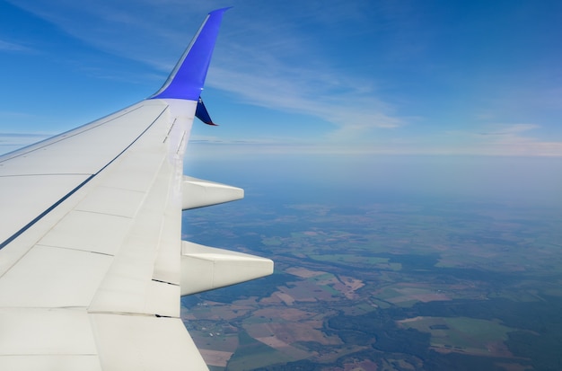 Asa de avião branco no contexto das nuvens no céu.