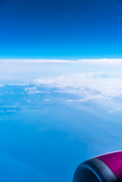 Asa de avião com céu azul e nuvem