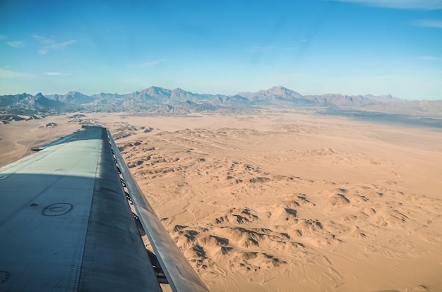 Asa de avião no Saara. Deserto quente de areia amarela sem fim.