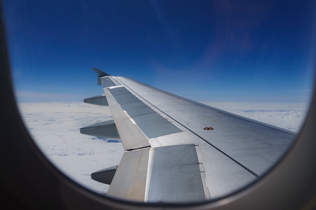 Asa de um avião voando acima das nuvens olhar da janela da cabine