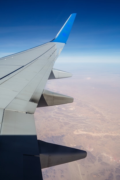 Asa do avião no ar contra um céu azul