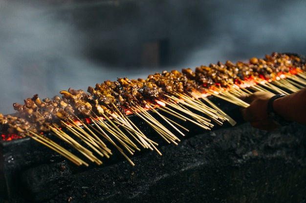 Foto asado de carne, pollo y cordero satays con carbón vegetal.