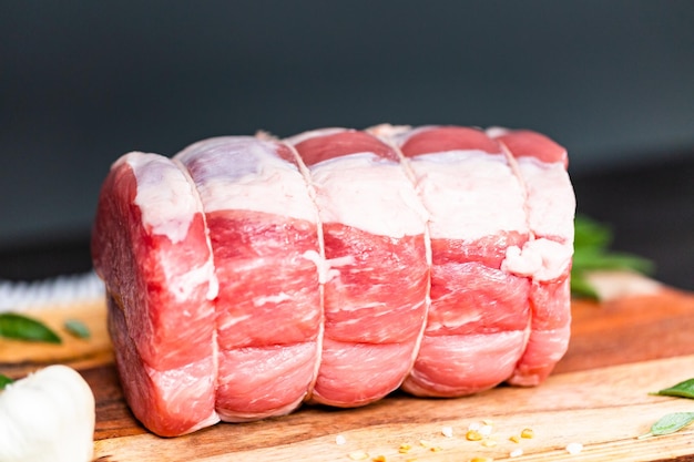 Asado de cerdo deshuesado crudo en la tabla de cortar.