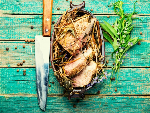 Asado de cerdo en heno con hierbas