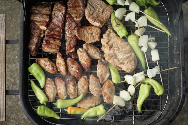 Asado de cerdo y pollo a la parrilla para hacer la cena de barbacoa.