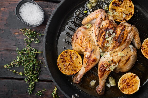 Asador de pollo casero con tomillo y limón, sobre la mesa de madera antigua, vista superior