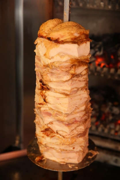Asador vertical con carne asada en la cocina del restaurante
