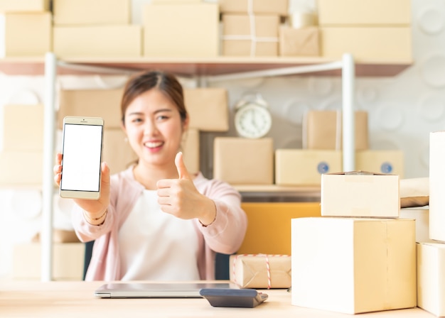 Asain mulher mostrando smartphone com o polegar para cima