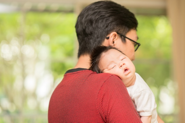 Asain Vater hält sein Baby zur Hand