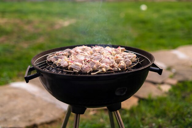 Asar carne de barbacoa a la parrilla al aire libre en el patio trasero.