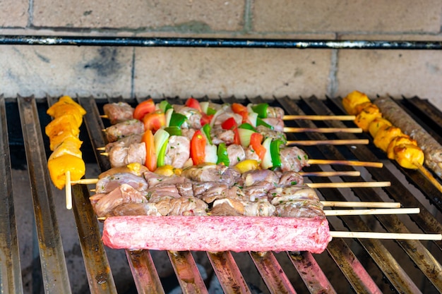 asar espetinho de carne (brocheta de carne tradicional brasileña) en una parrilla de barbacoa