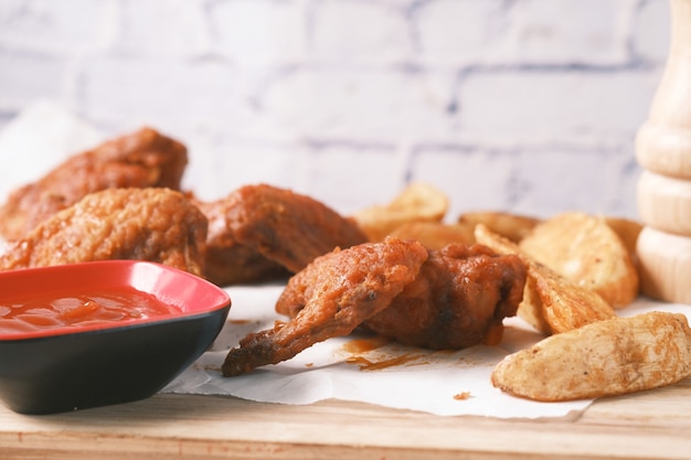 Asar gajos de pollo y camote en una tabla