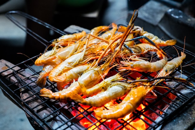 Asar a la parrilla los camarones en brochetas. Comida callejera en Tailandia.