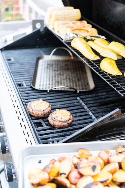 Asar verduras frescas de verano en una parrilla de gas al aire libre.