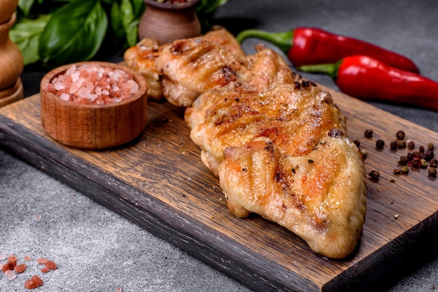 Foto asas de frango assadas com sementes de gergelim e molho em uma tábua de madeira