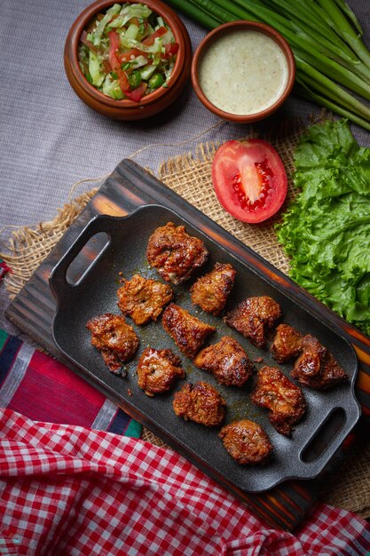 Asas de frango assadas servidas com diferentes molhos e limão Fundo preto