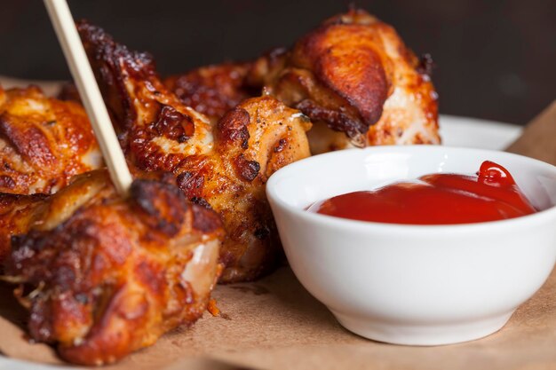 Asas de frango assado junto com ketchup, as asas são cozidas e prontas para comer em um café