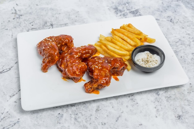 Asas de frango búfalo quentes e picantes e batatas fritas crocantes com molho branco