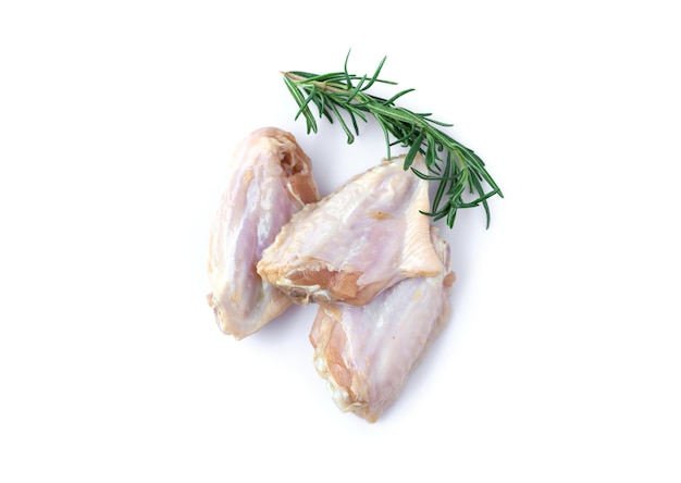 Foto asas de frango cru com alecrim isolado no fundo branco