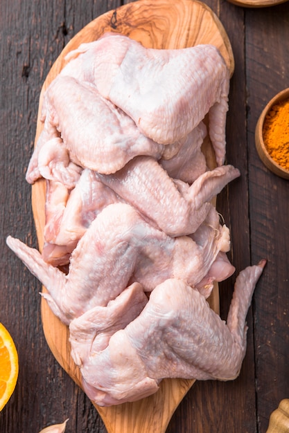 Asas de frango cru com ingredientes para cozinhar