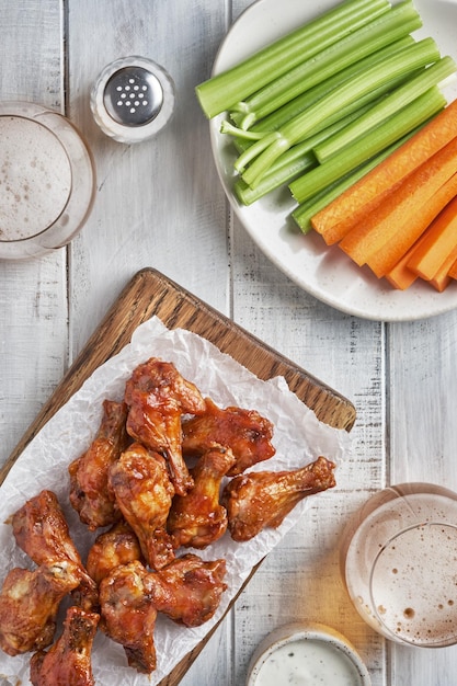 Foto asas de frango de búfalo com aipo e cerveja