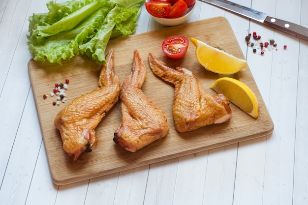 Asas de frango defumado com tomate e limão de alface fresca. copie o espaço.