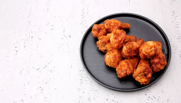 Asas de frango frito coreanas isoladas em um fundo cinza no estúdio.